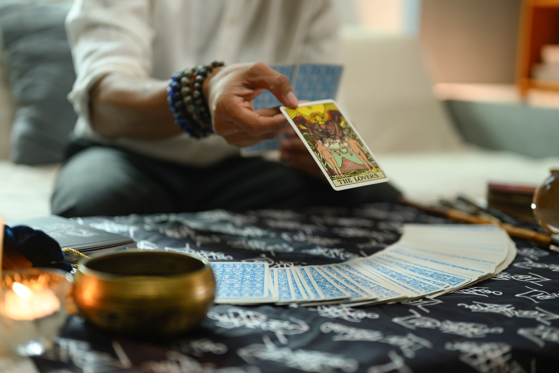 Diseuse de bonne aventure révélant la carte de tarot « Les amoureux » lors d’une séance de lecture. Concept de sorcellerie et de divination